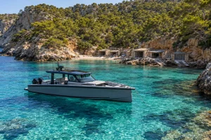 Barco fondeado en una cala del norte de Ibiza junto a casetas varadero